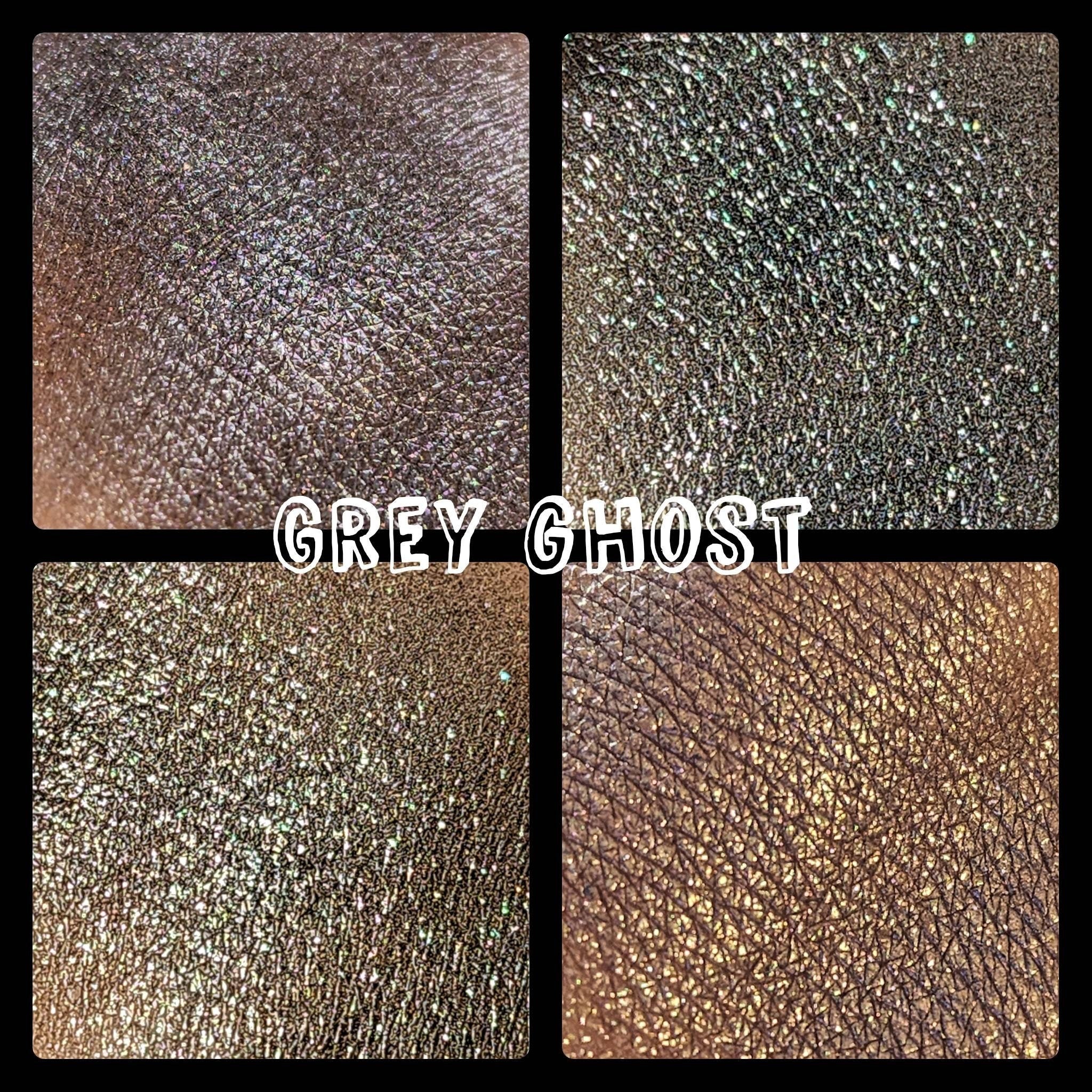 Close-up of pressed multichrome eyeshadow pan shifting from grey to iridescent hues with shimmer finish