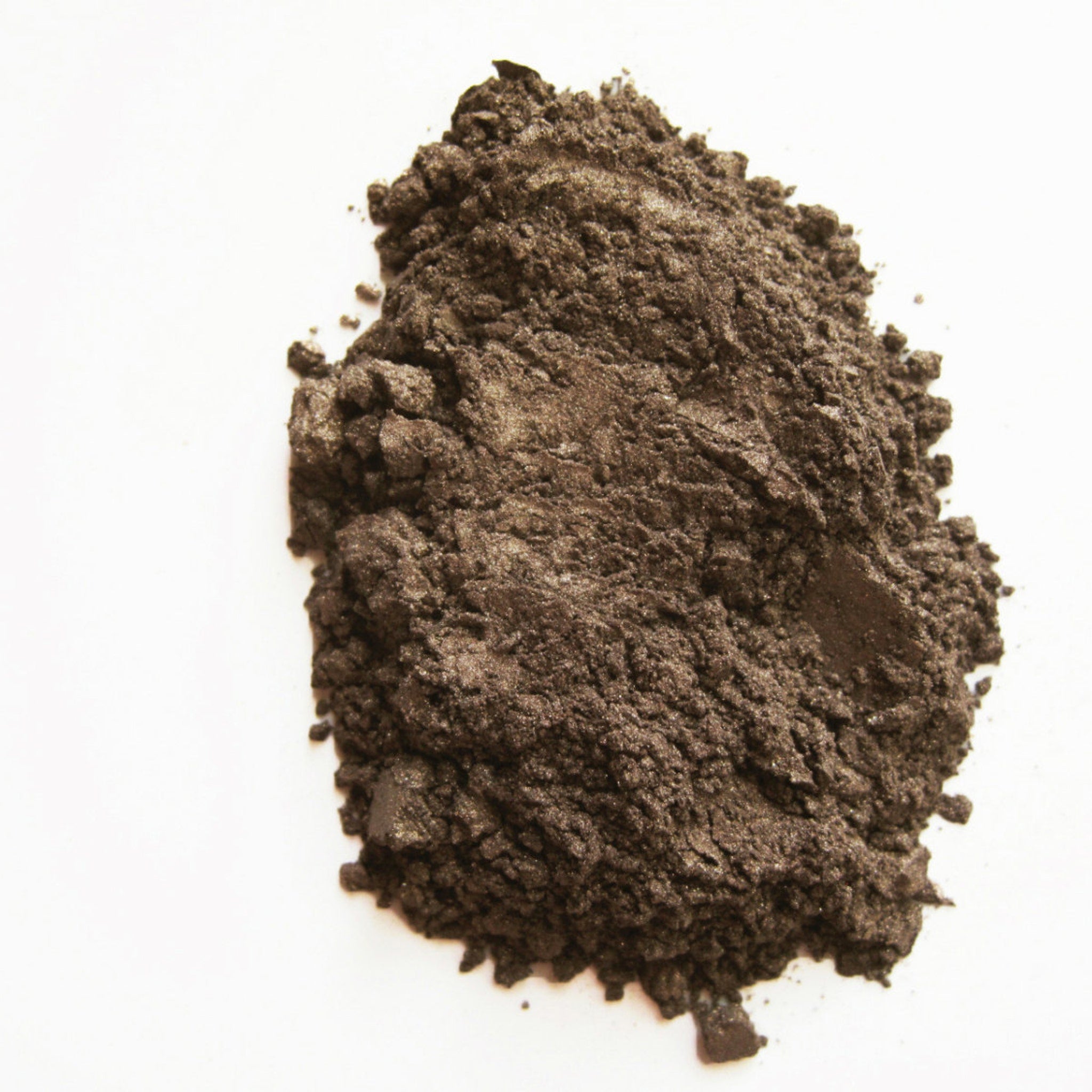 Close-up of warm cognac mineral eye shadow with rich, shimmery finish in compact case
