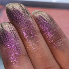 Close-up of pressed purple-olive eyeshadow pan with shimmering chameleon color shift and sparkling trichrome finish