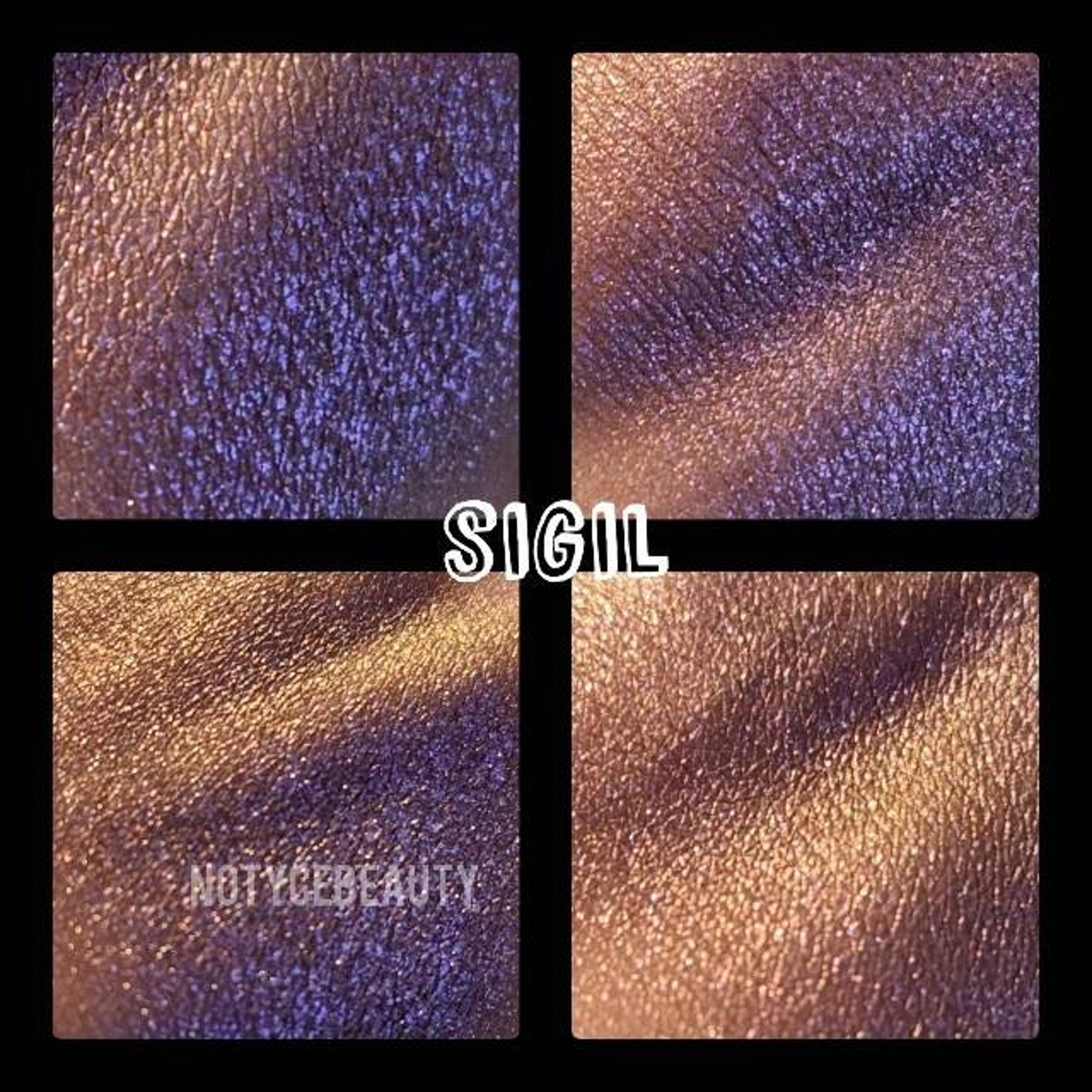 Open compact showing pressed purple-olive shimmer eyeshadow with color-shifting trichrome finish