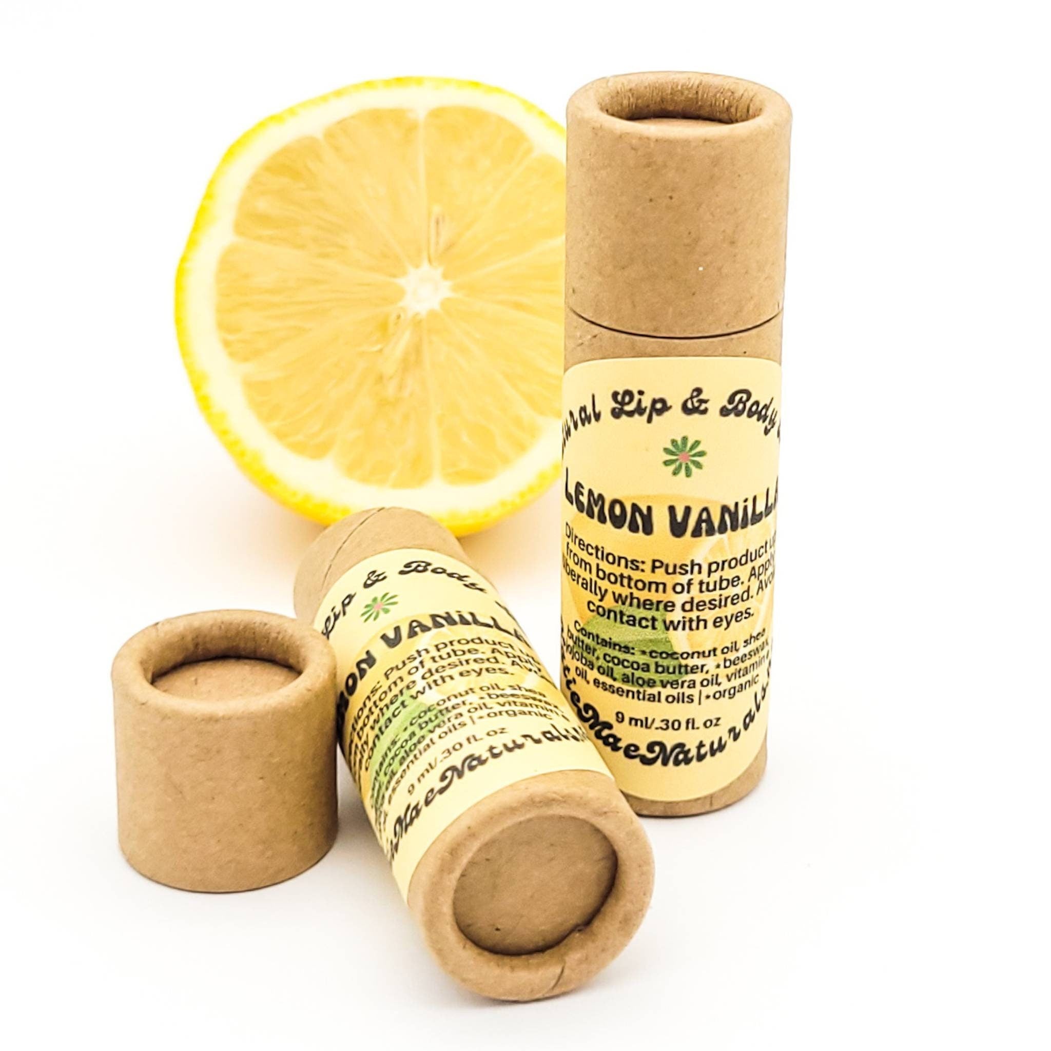 Lip balm tubes in brown cardboard with yellow label, and lemon slice, Mae Naturals brand visible