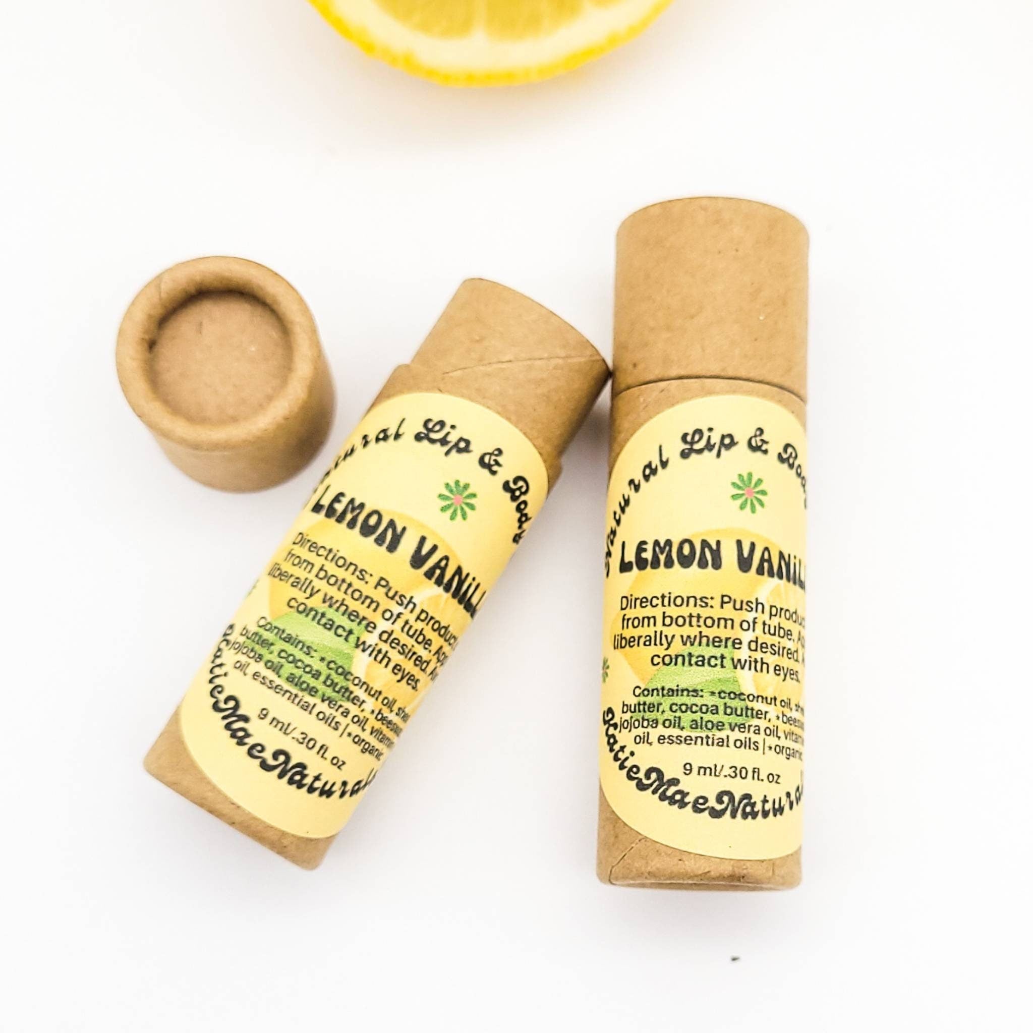 Lip balm tubes in brown cardboard with yellow label, "Lemon Vanilla" text, and Katie Mae Naturals brand name