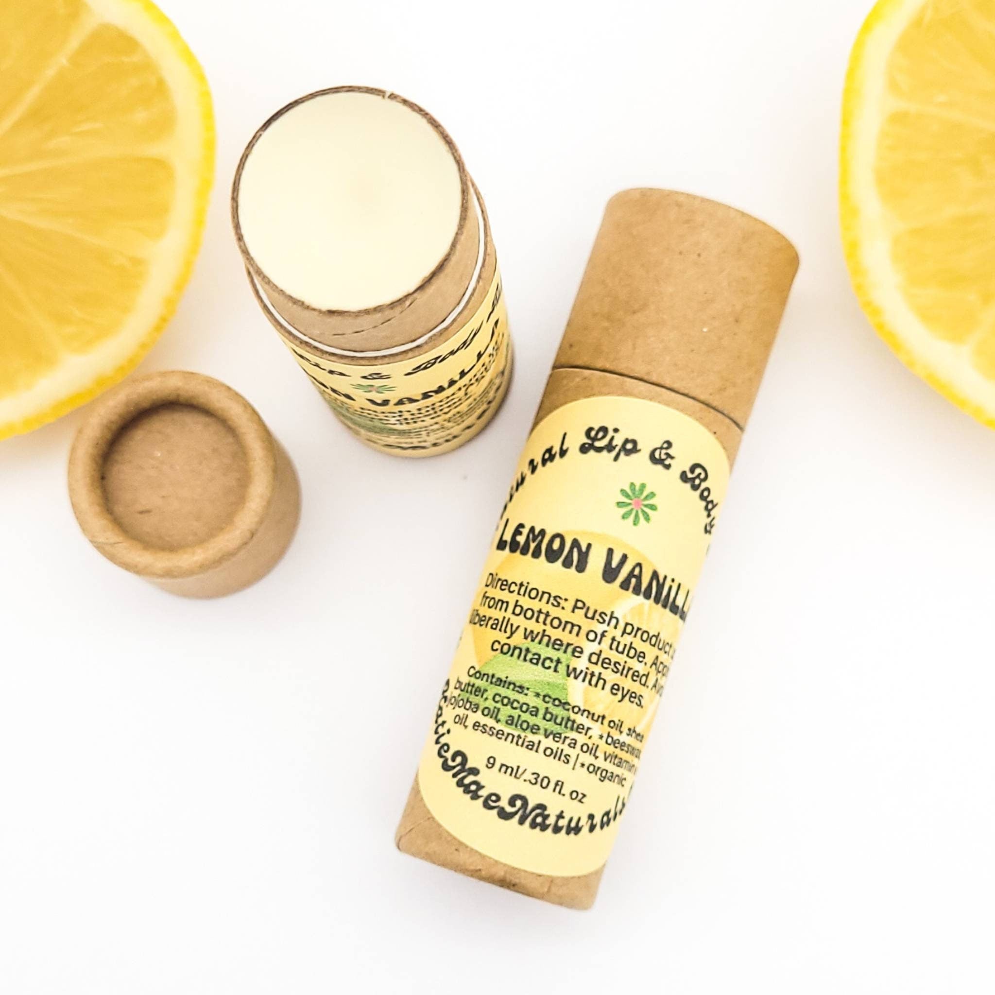 Lip balm tubes in brown cardboard with yellow labels and lemon slices on white surface