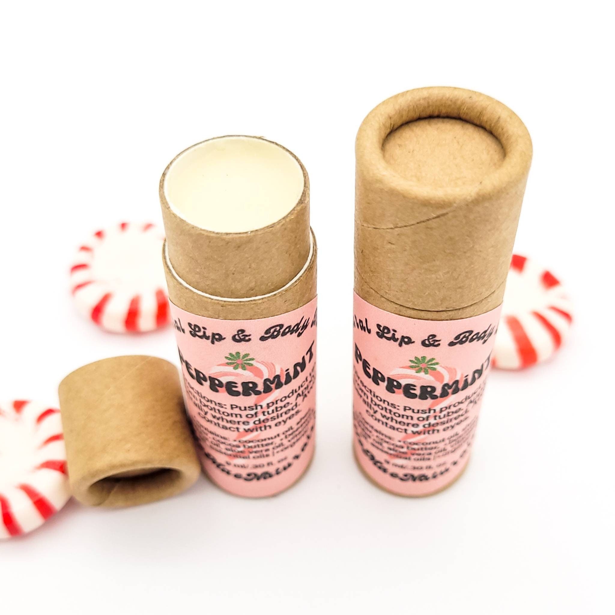 Lip balm tubes with pink label, brown cardboard, and red and white mints around them