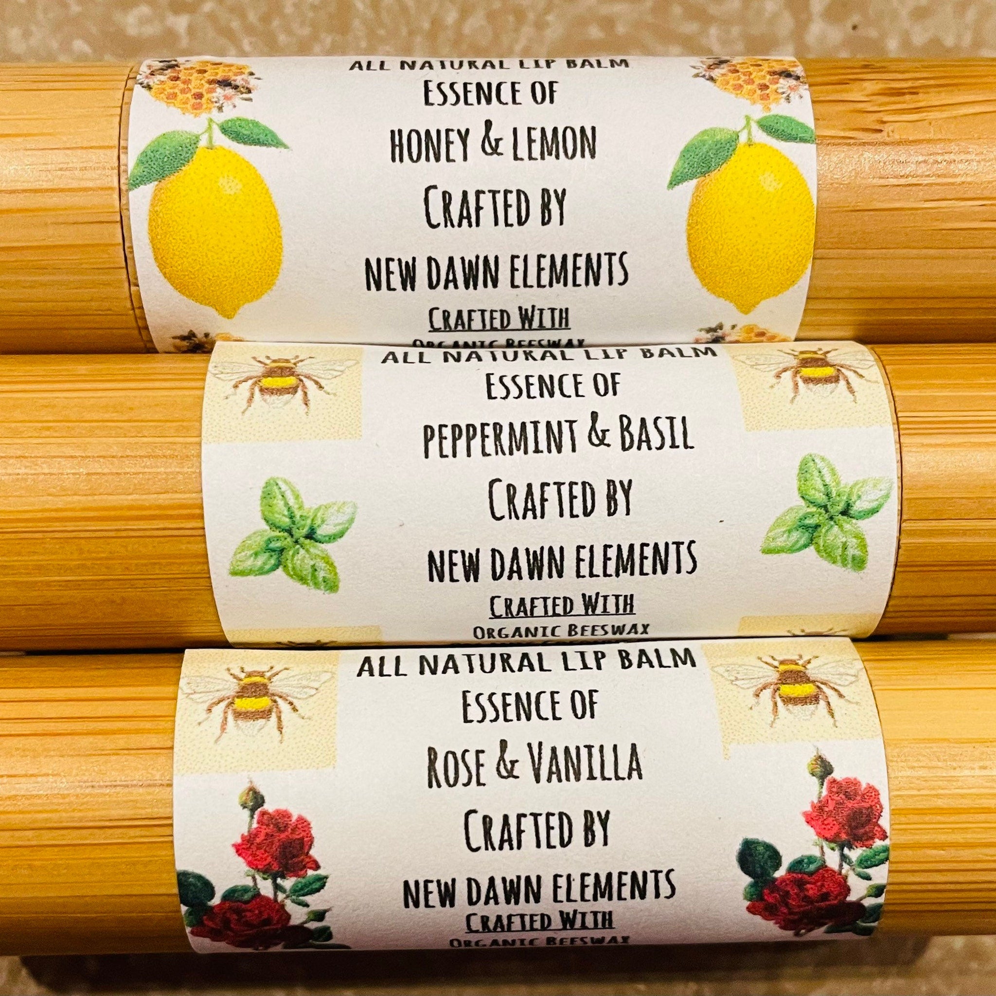 Lip balm tubes with yellow, green, and red illustrations, bamboo material, New Dawn Elements brand