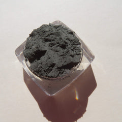 Close-up of loose dark matte green tea mineral eyeshadow with fine mica shimmer in a jar