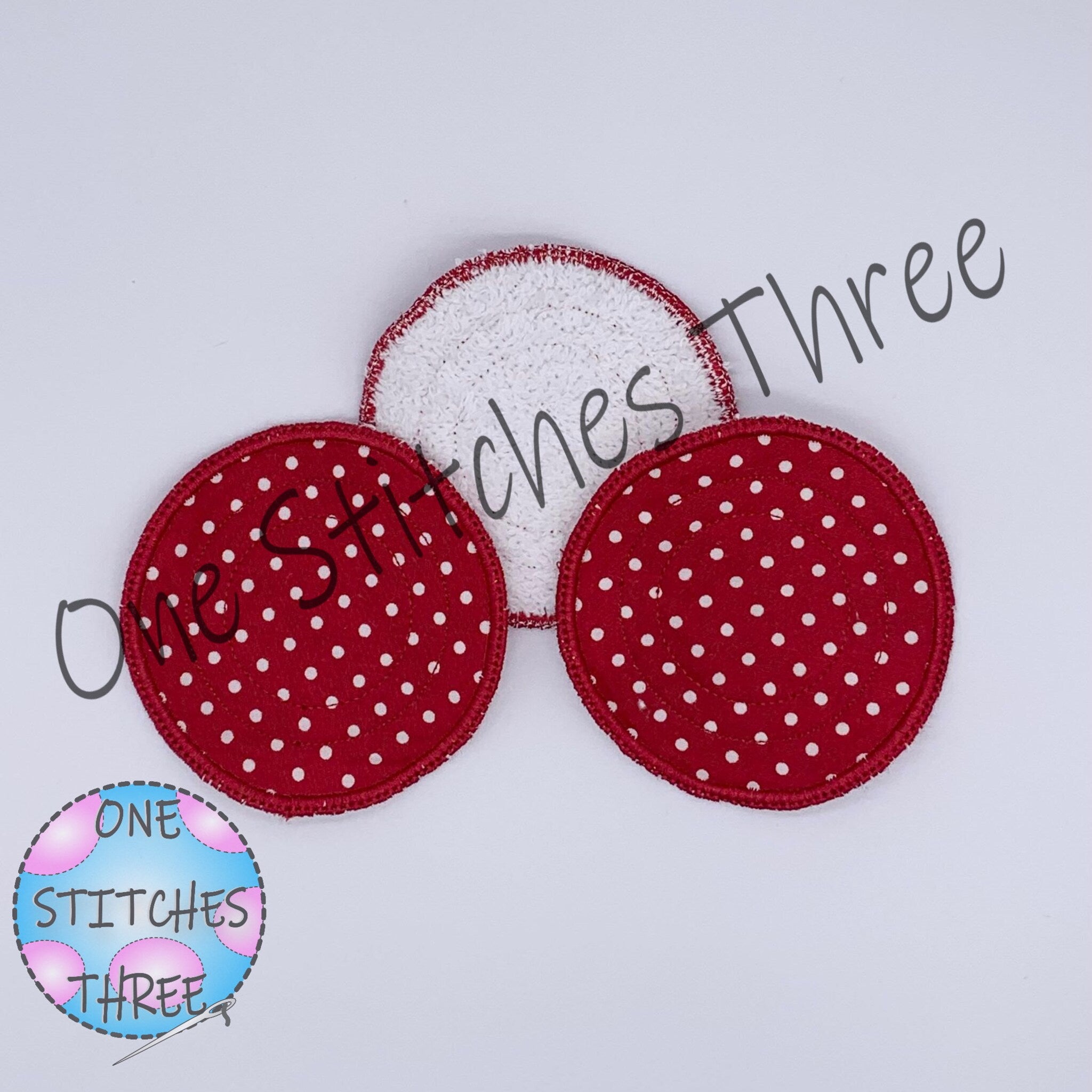 Reusable face pads with red polka dot pattern and white terrycloth, ONE STITCHES THREE logo visible