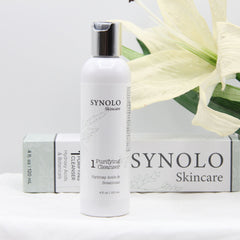 Facial cleanser bottle white with silver cap, Synolo Skincare branding, floral accents