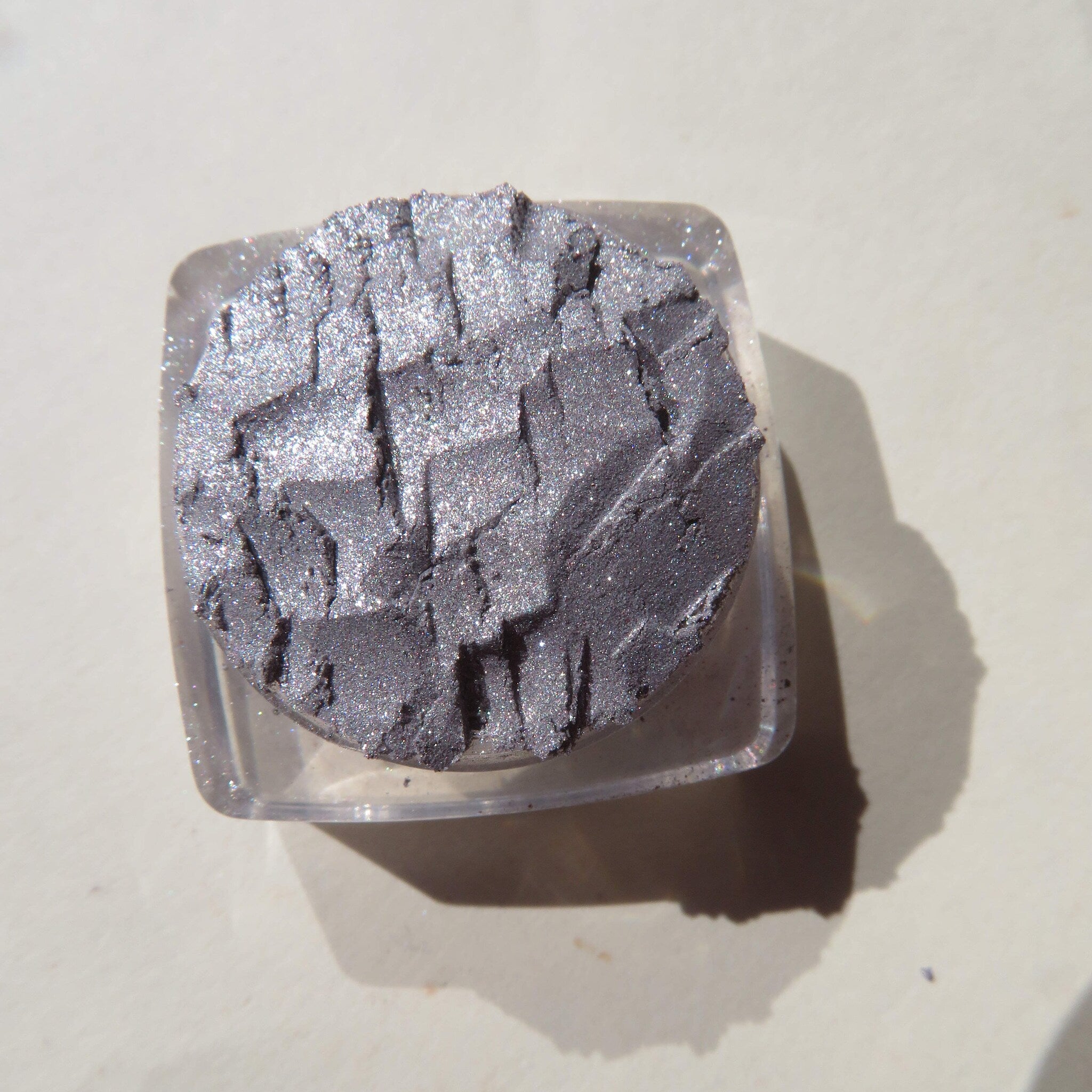Close-up of shimmery silver chrome loose pigment eyeshadow with reflective metallic finish