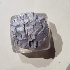 Close-up of shimmery silver chrome loose pigment eyeshadow with reflective metallic finish