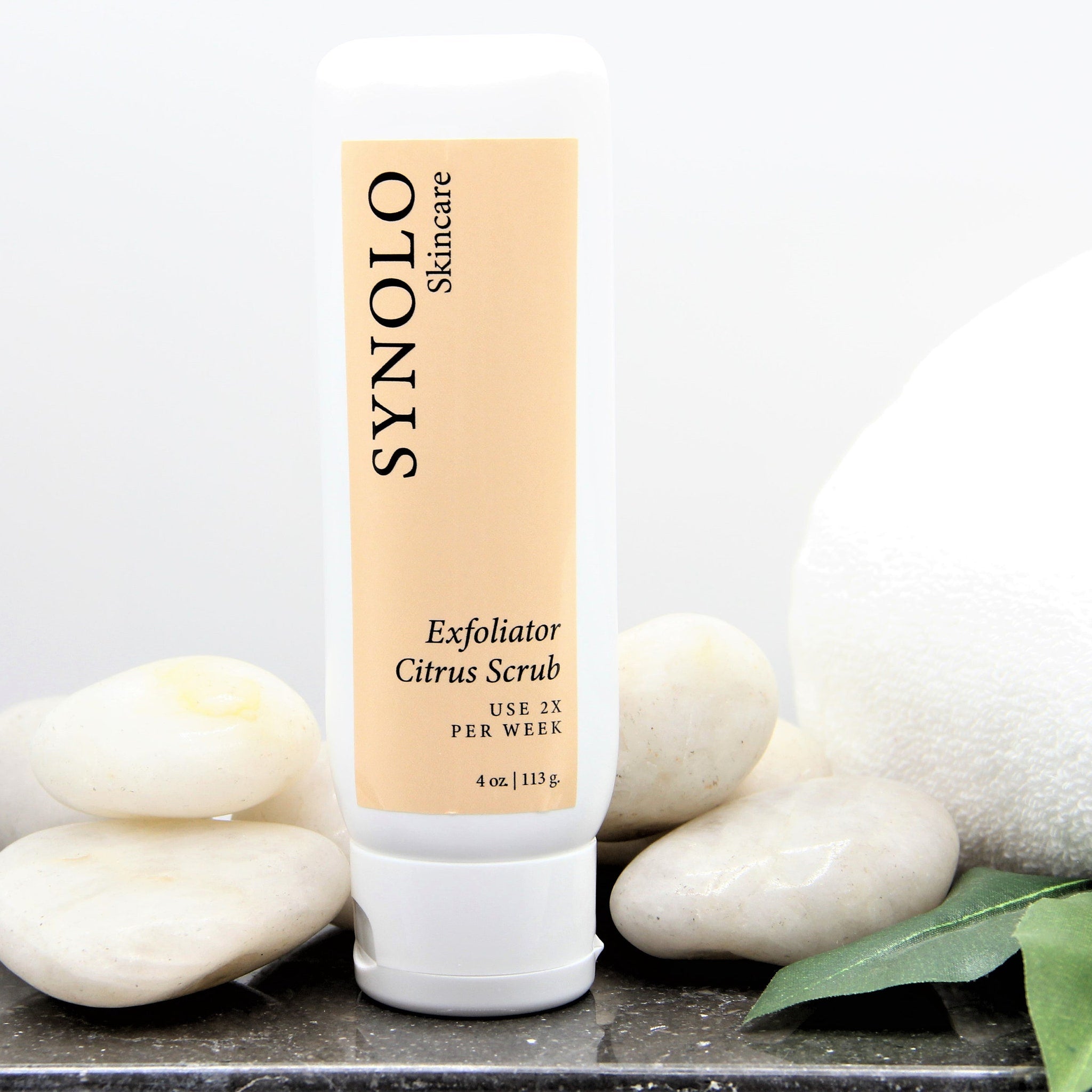 Exfoliator Citrus Scrub white bottle with beige label, SYNOLO Skincare brand name visible