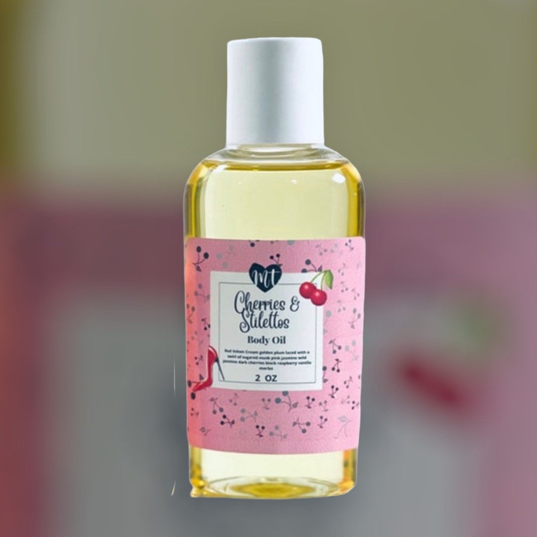Body oil bottle with white cap, pink label, and floral pattern, "Cherries & Stilettos" brand