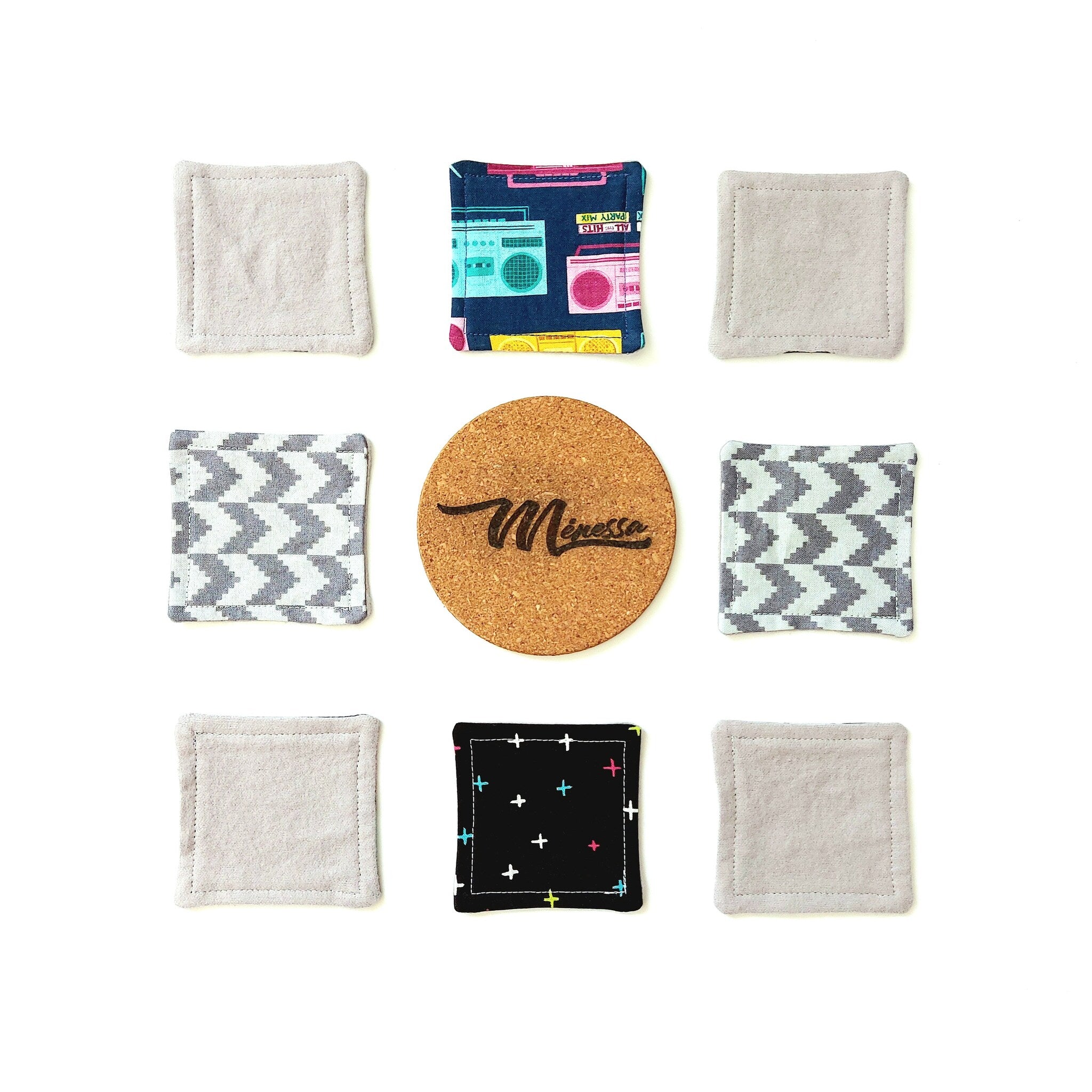 Coasters, various colors and patterns, including gray, blue, and black, with a cork coaster in the center with "Minessa" text