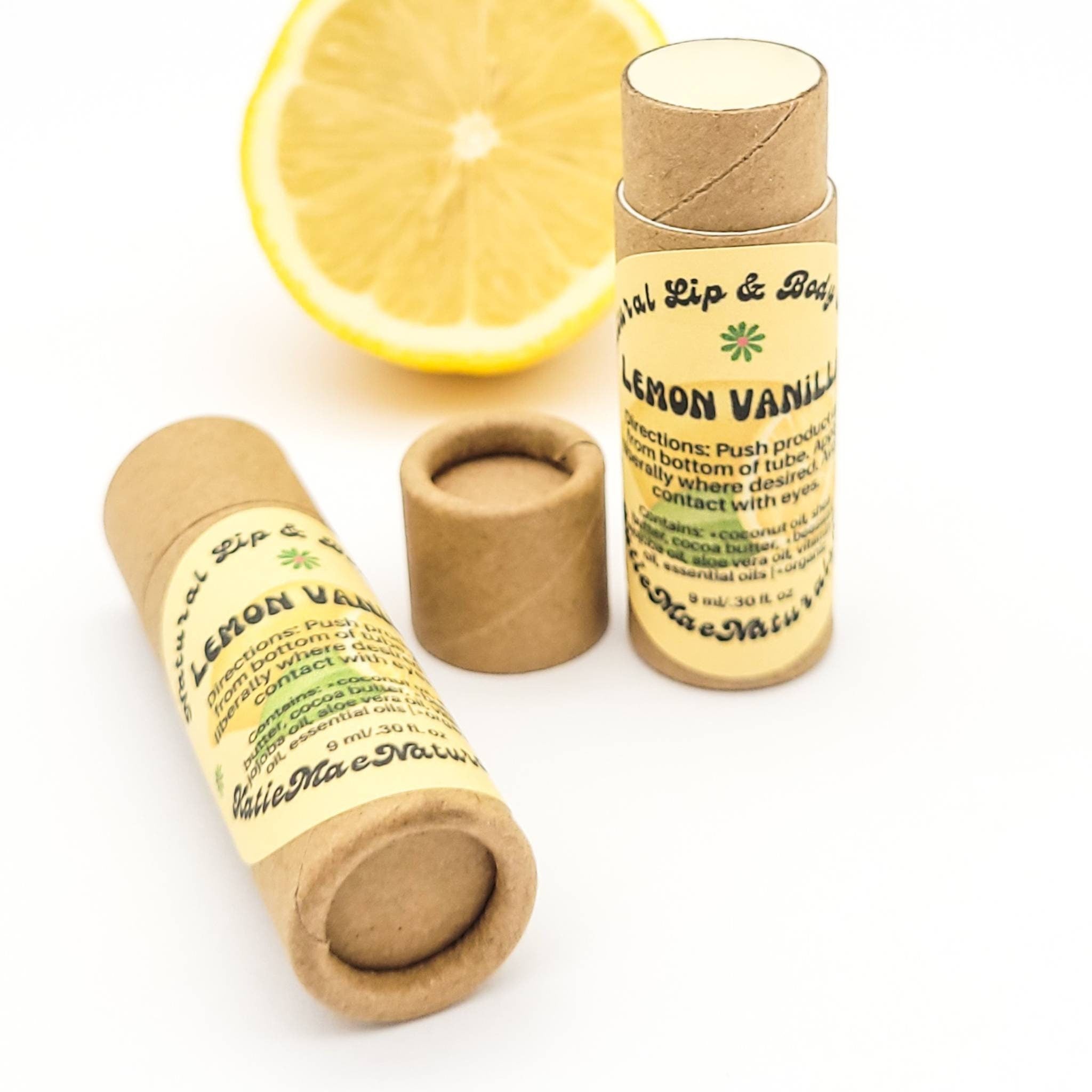 Lip balm in cardboard tube with Lemon Vanilla label and sliced lemon in background