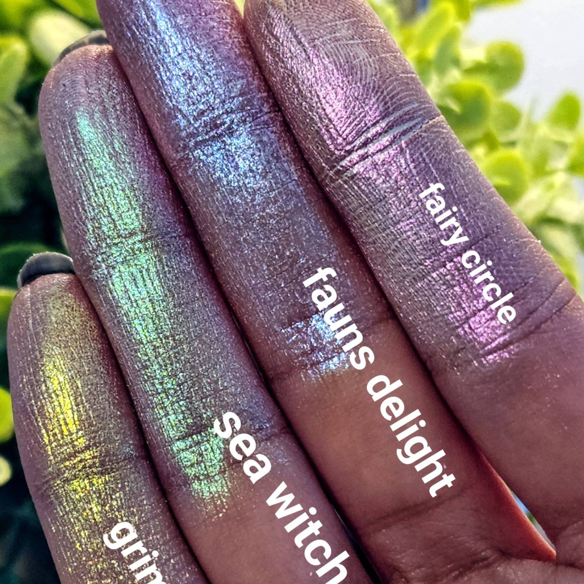 Close-up of pressed neon green and pink duochrome eyeshadow pan with iridescent shimmer, showing color shift.
