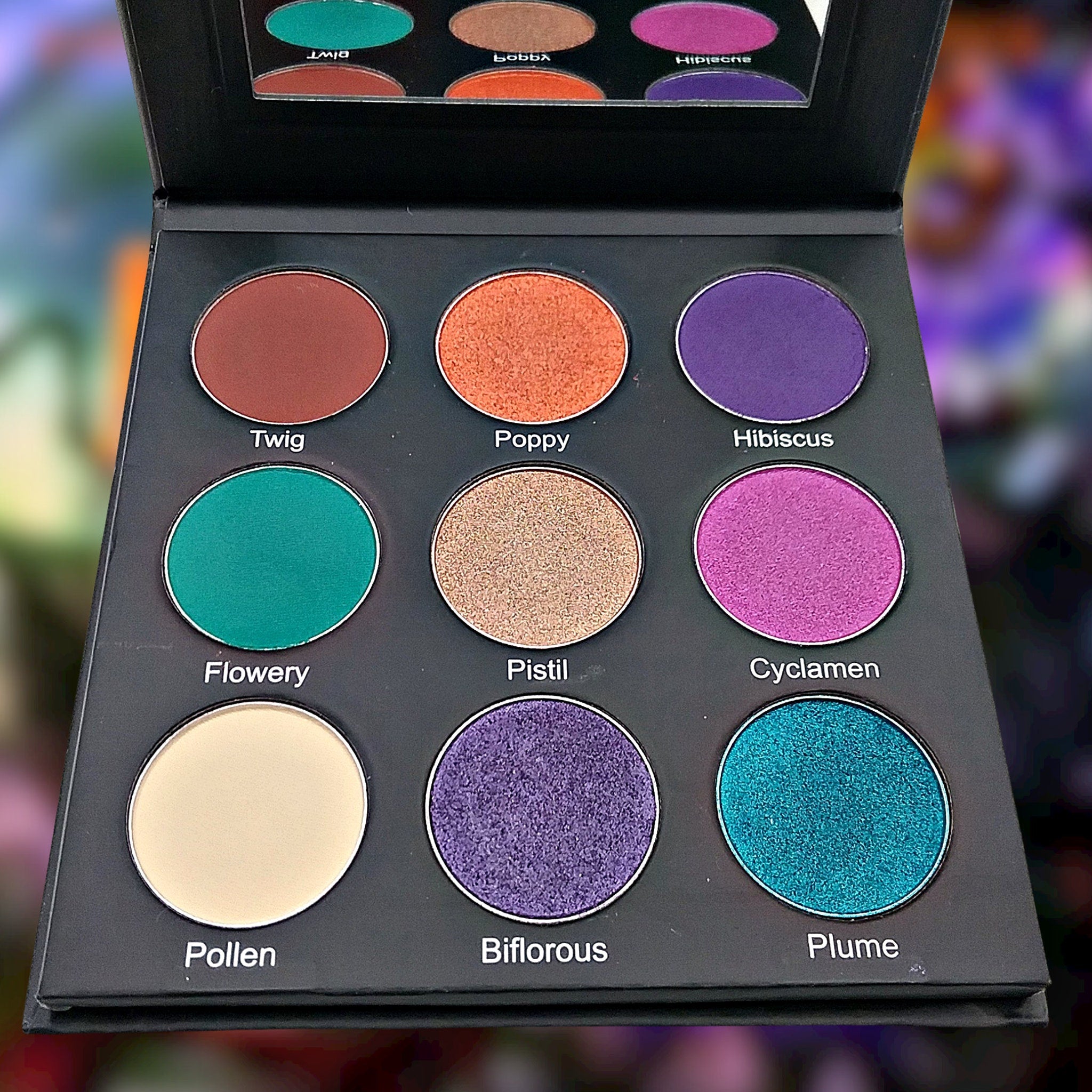 Eyeshadow palette with multiple colors, matte and shimmer finishes, in a black compact