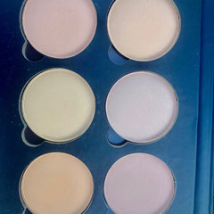 Close-up of matte and shimmer eyeshadow pans in neutral brown and taupe shades with smooth powder texture