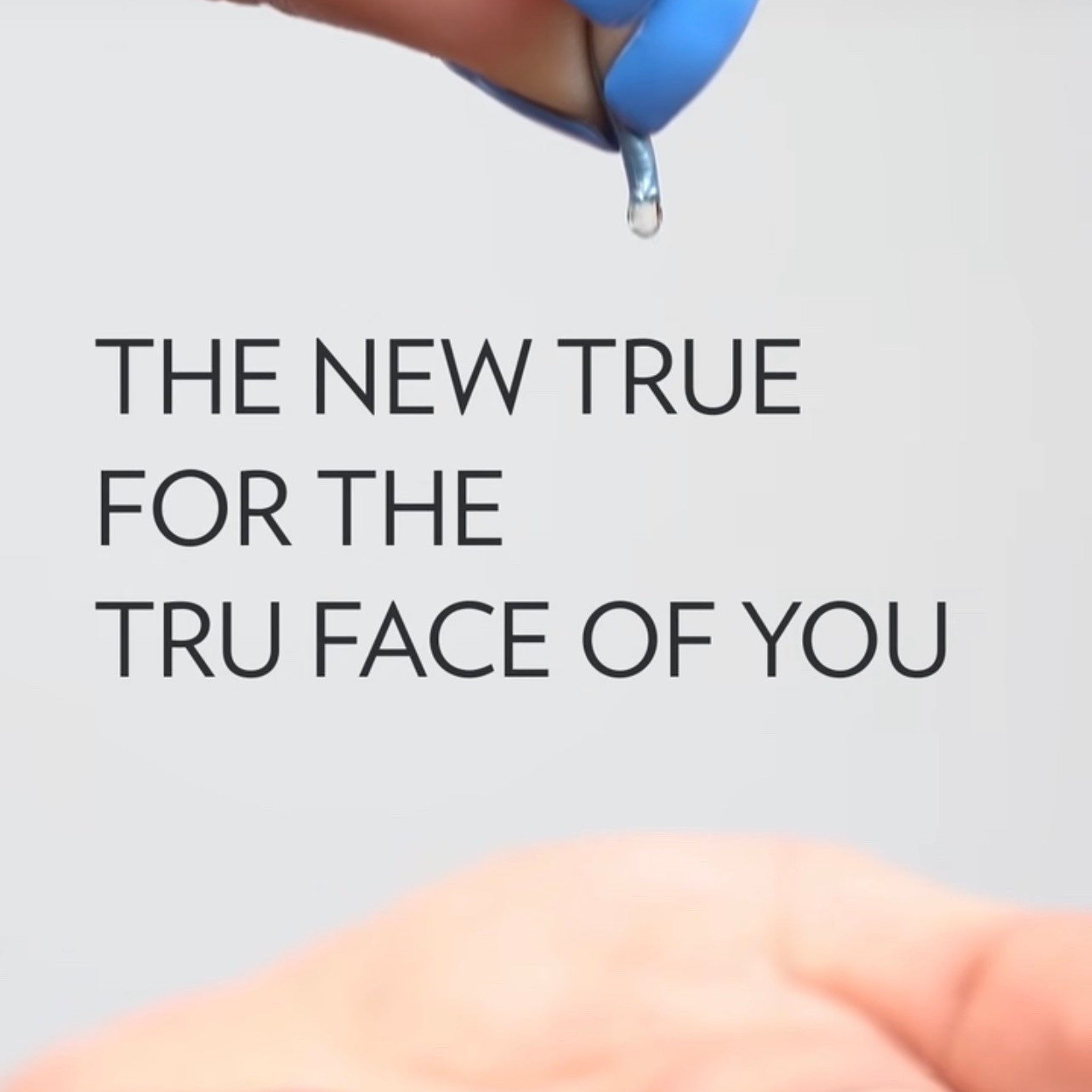 Blue liquid droplet falling from blue applicator, white background, "THE NEW TRUE" text