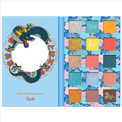 Eyeshadow palette with blue, gold, and multi-colored shades, Rude brand name visible, dragon design on cover