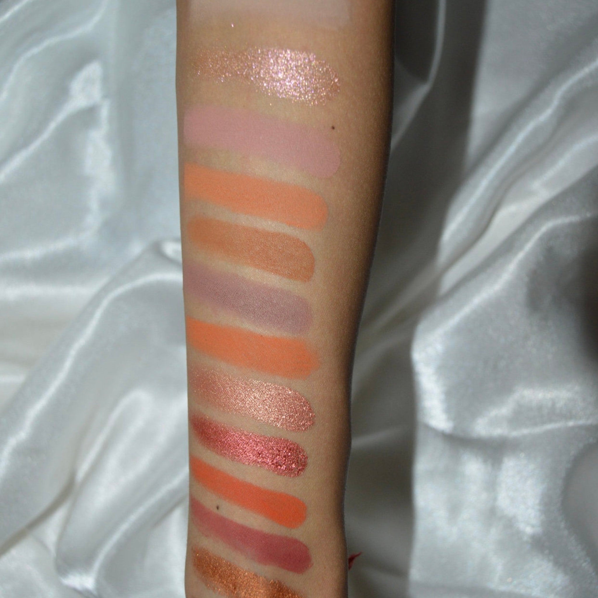 Side view of eye shadow palette showing stacked rectangular pans with matte and shimmer shades in warm neutrals
