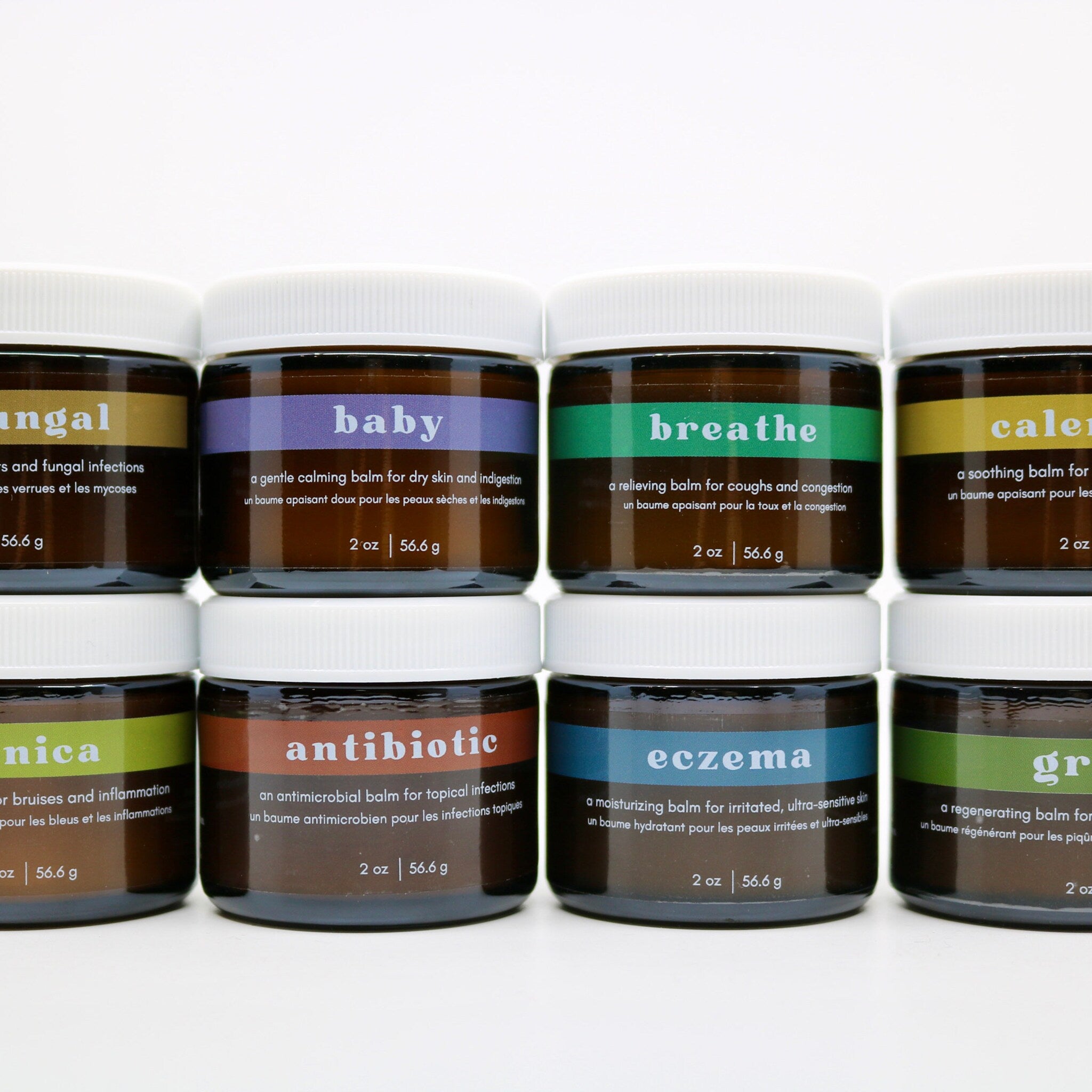 Balm jars with white lids, brown glass, and colorful labels for different uses