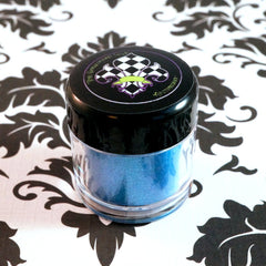 Side view of iridescent turquoise and royal blue loose mineral eyeshadow shimmering in sunlight