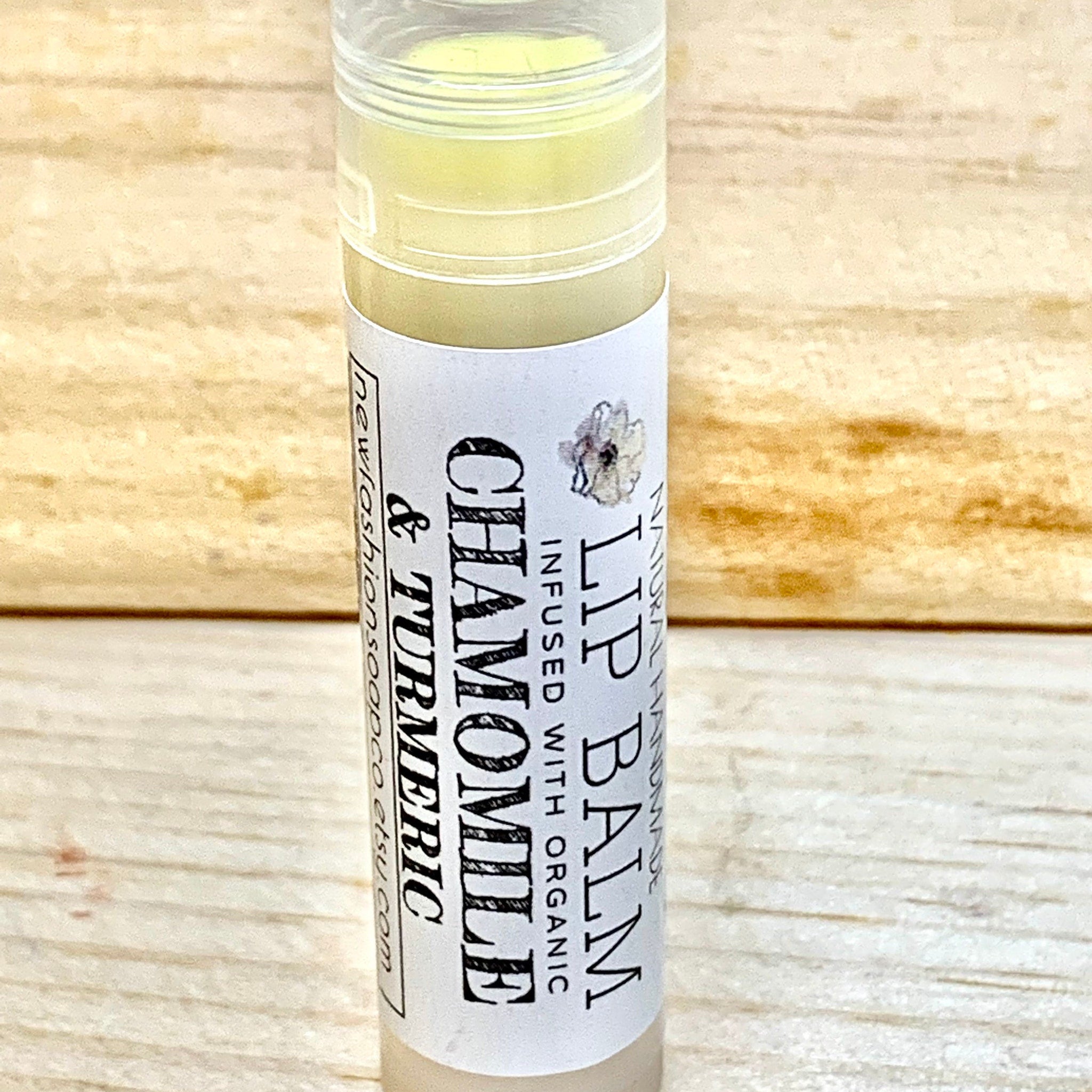 Lip balm tube with white label, yellow balm, and wooden background