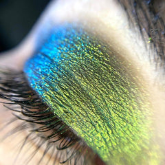 Close-up of loose multi-chrome eye shadow pigment showing shimmering color shift in vibrant hues