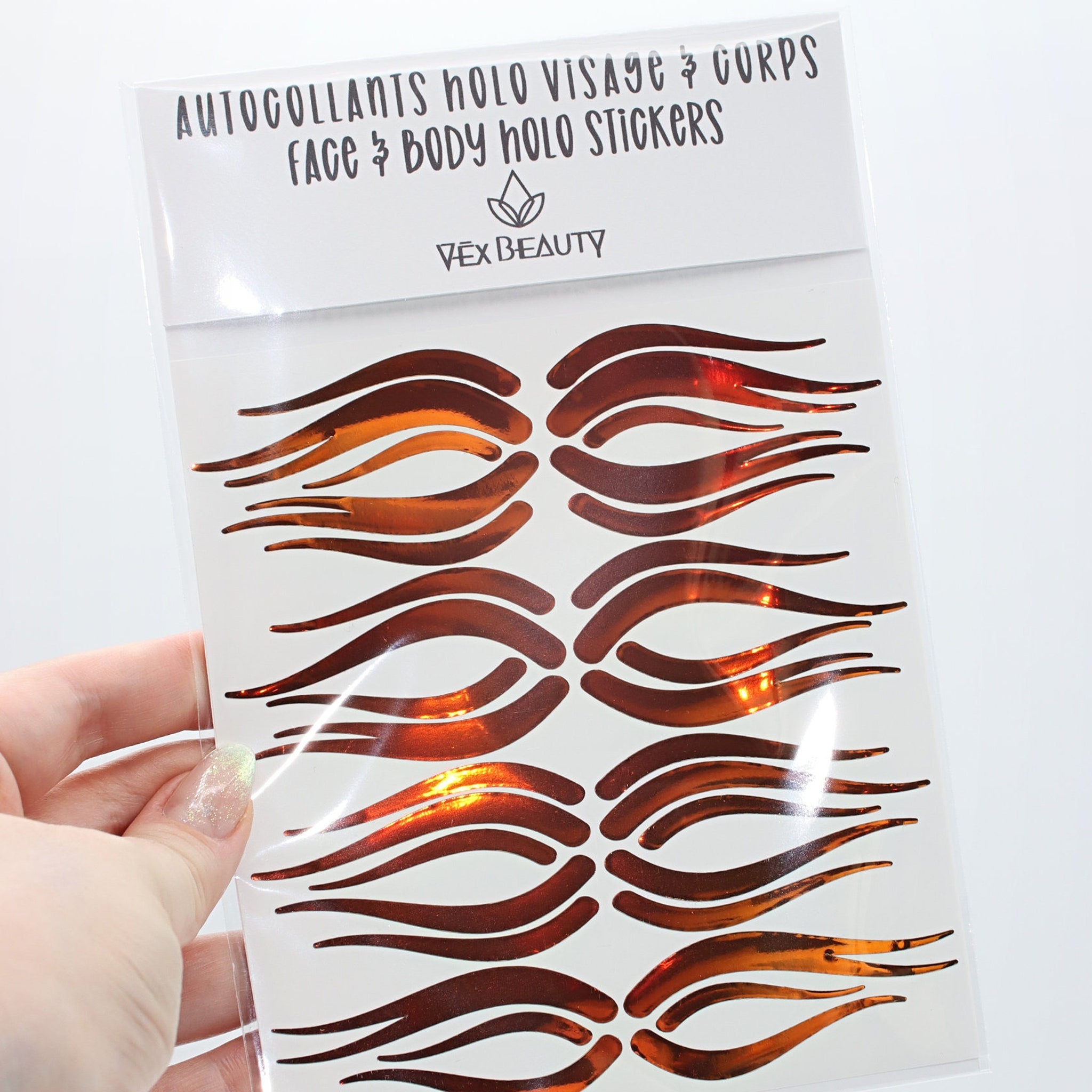 Face and body holo stickers in copper metallic, Vex Beauty brand, held in hand
