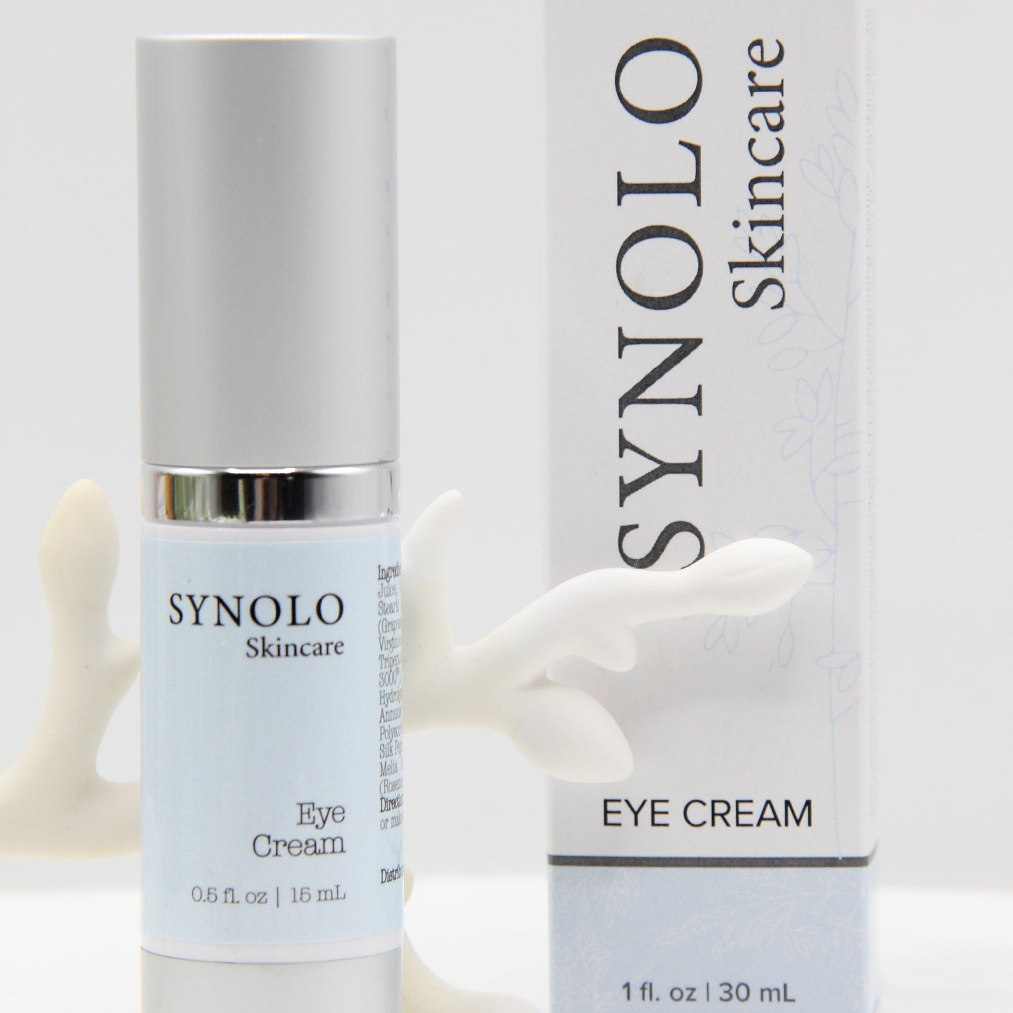 Eye cream bottle with silver cap, light blue label, and white box with SYNOLO Skincare text