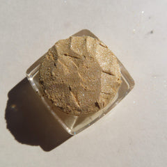 Glitter eyeshadow, gold shimmer, textured powder, clear square container