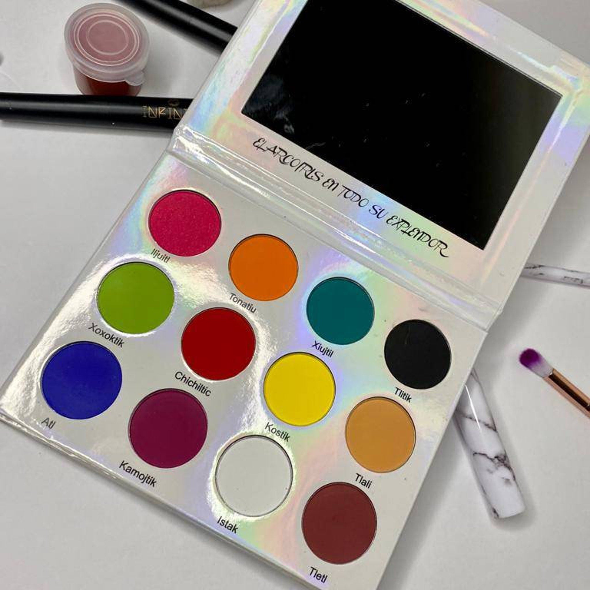 Side view of eye shadow palette showing stacked rectangular pans with matte and shimmer shades in neutral tones