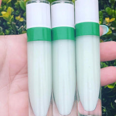 Lip gloss tubes with white and green accents, held in hand