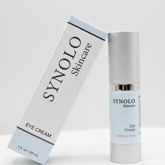 Eye cream product with white and light blue packaging, SYNOLO Skincare brand visible, silver cap