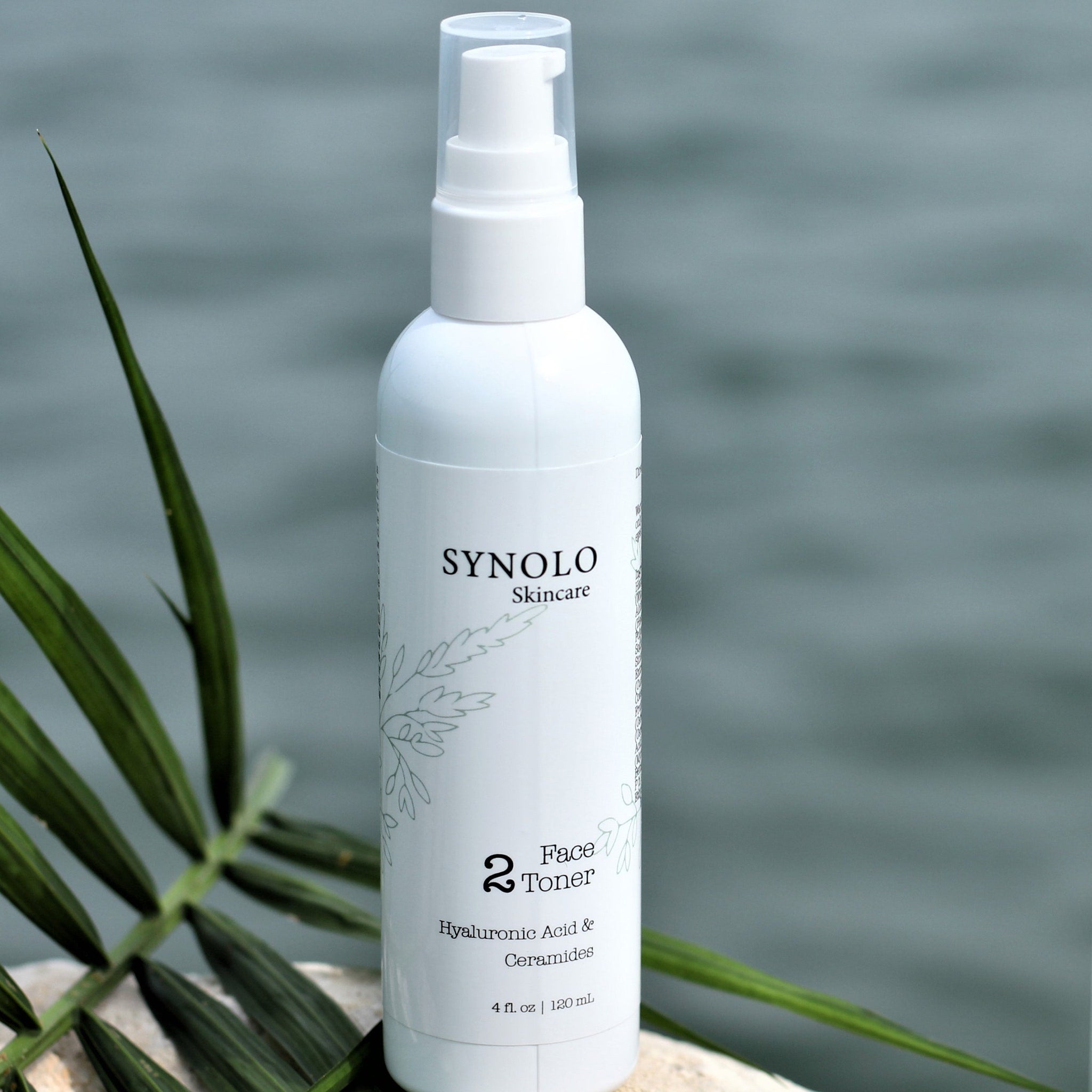 Face toner bottle, white plastic with clear pump, Synolo Skincare branding, with green leaf accent