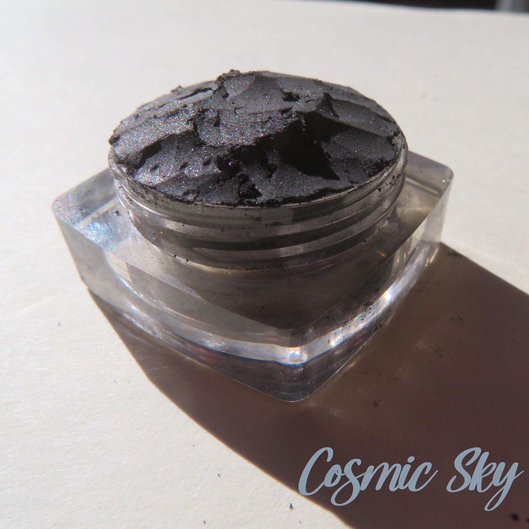 Black shimmer mineral eyeshadow in loose powder form with cosmic sparkle effect, vegan and cruelty-free