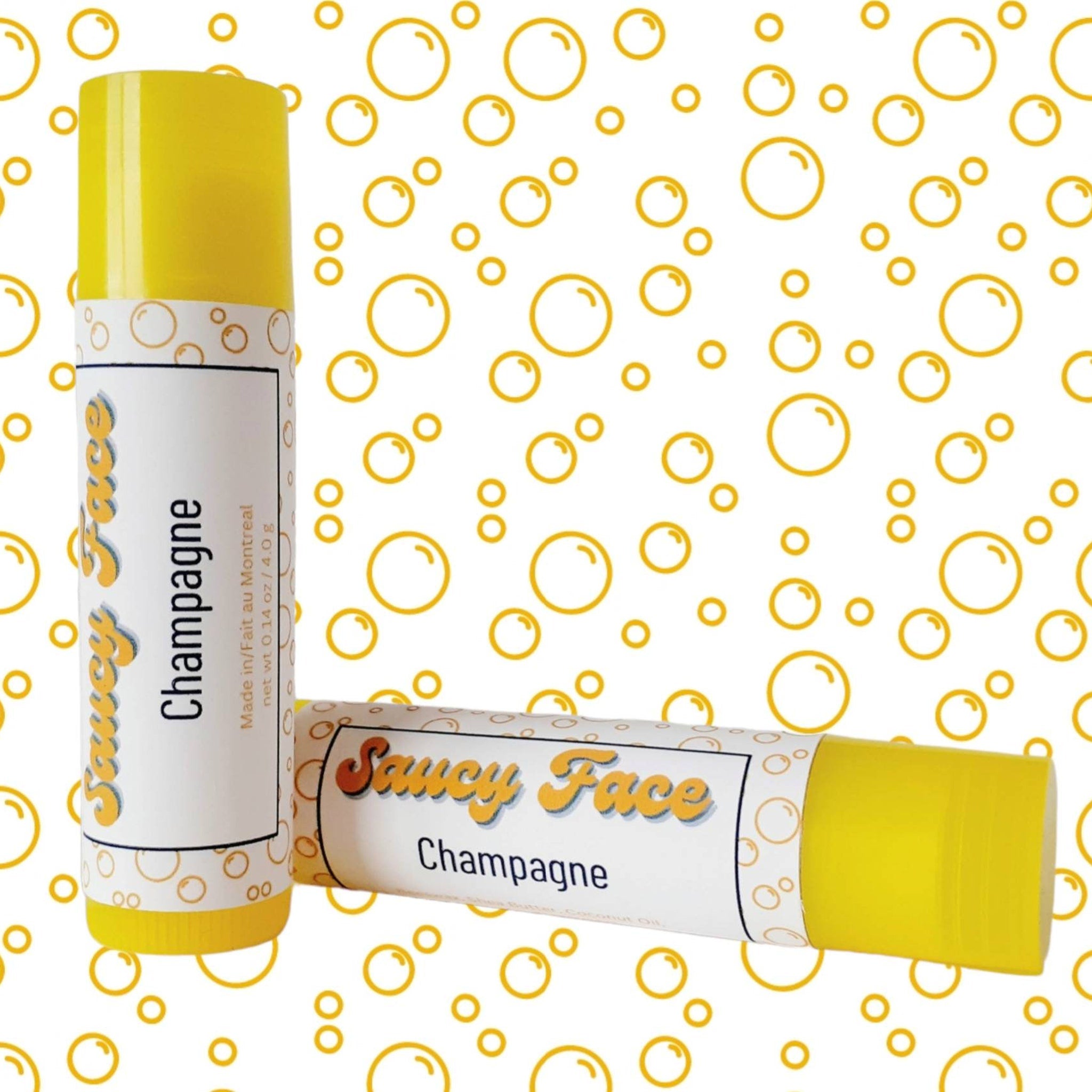 Lip balm tubes with yellow tops and white labels, "Saucy Face Champagne" text, on bubble pattern background.