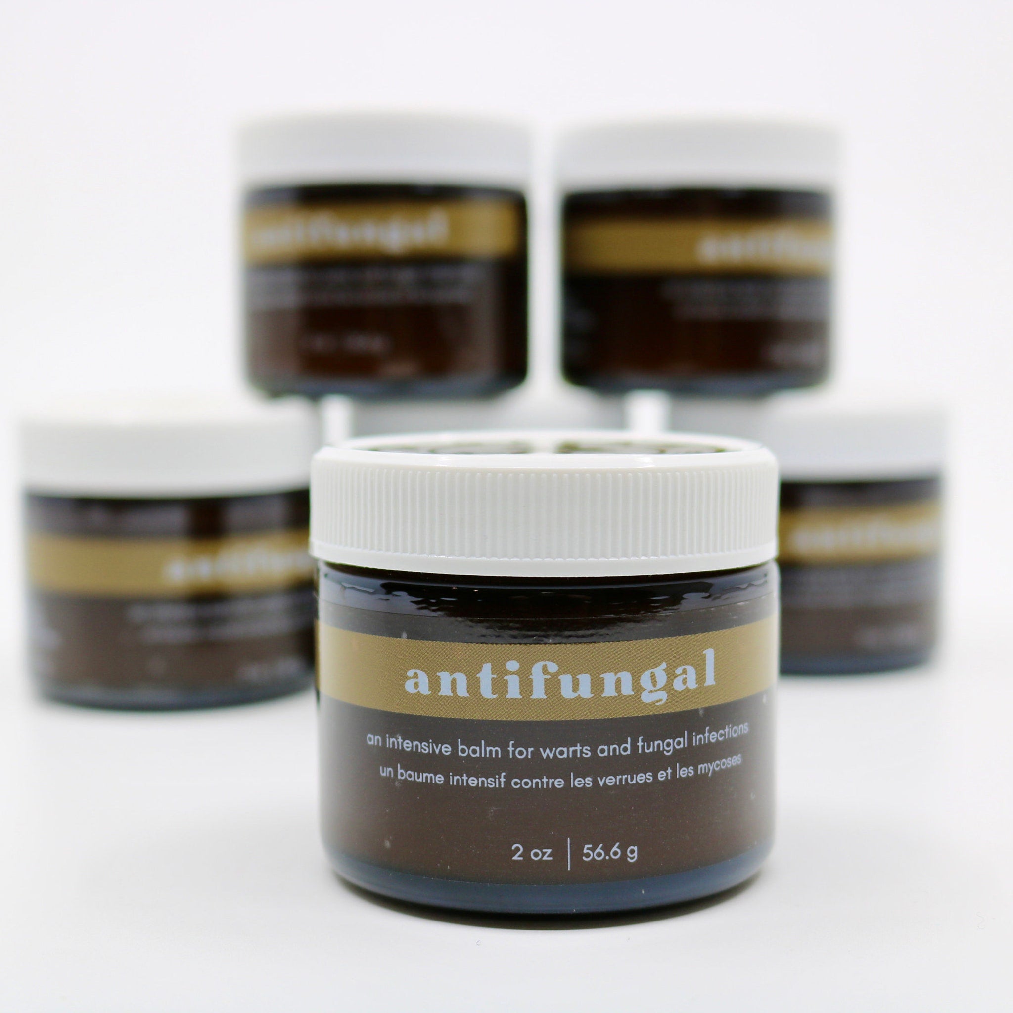 Antifungal balm jars, brown glass with white lid, gold label with "antifungal" text, multiple jars in stack