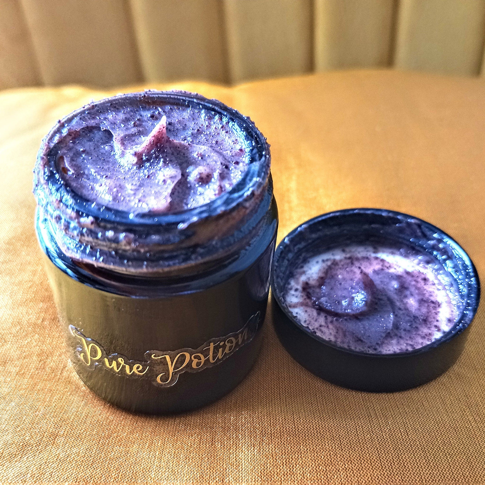Pure Potion jar with purple cream, black container, and gold text on a yellow surface.