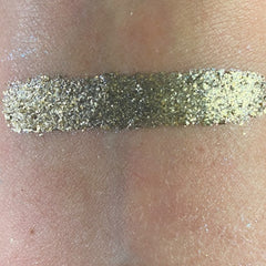 Hand applying shimmery silver eye shadow from palette to eyelid with brush