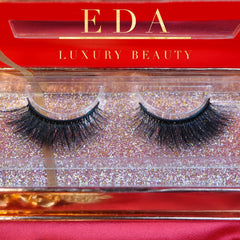False eyelashes with black lashes, clear band, and EDA Luxury Beauty text on red box