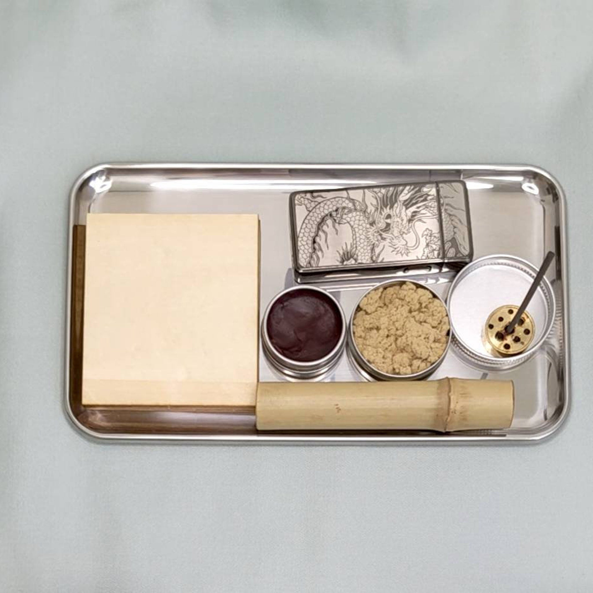 Incense set on metal tray with wooden block, bamboo tube, and various containers