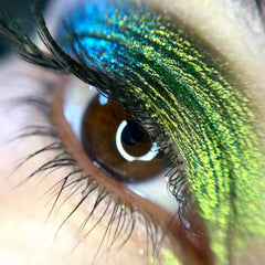 Close-up of loose multi-chrome eye shadow pigment in a jar with shimmering rainbow hues
