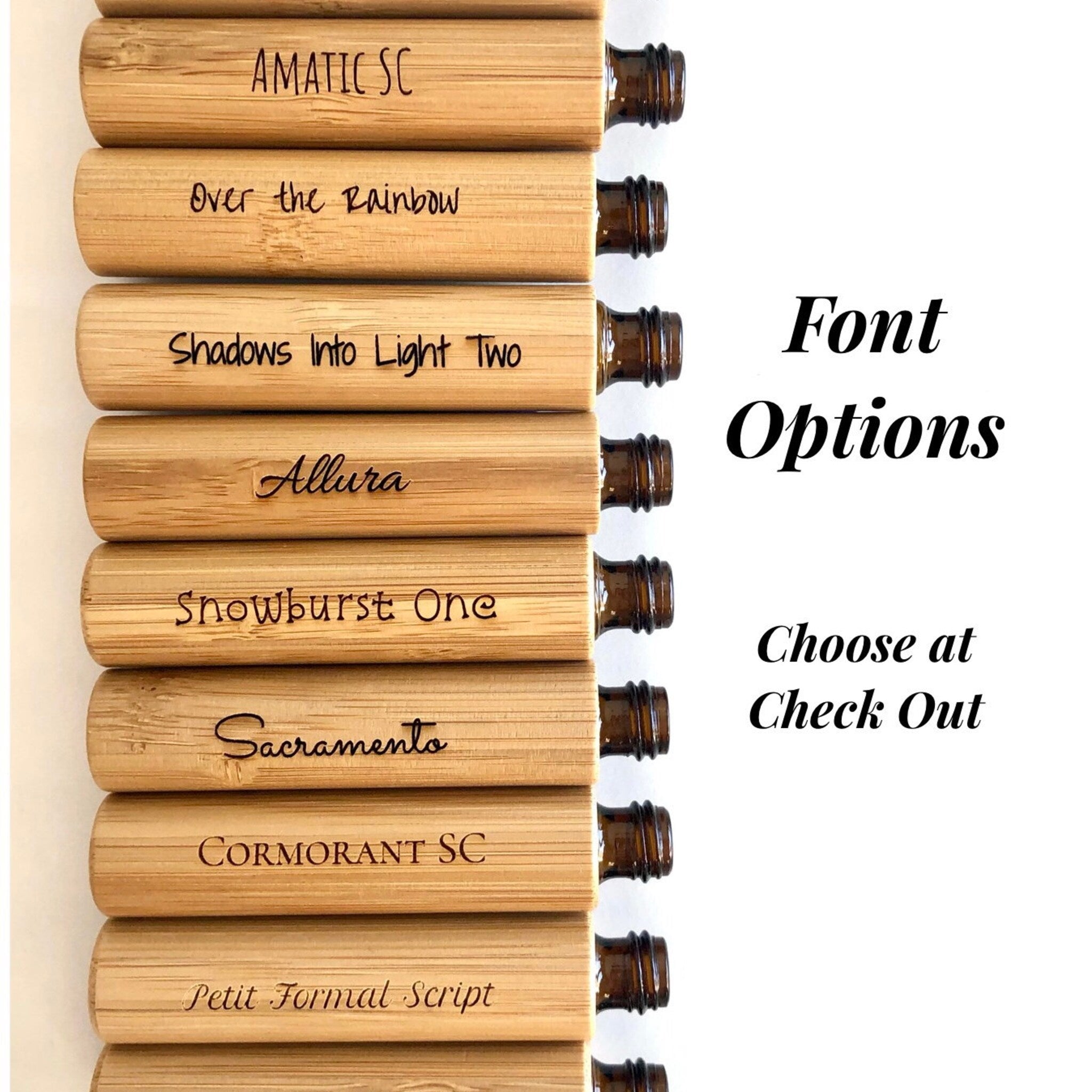 Essential oil roller bottles with bamboo casing and brown glass, various font options displayed