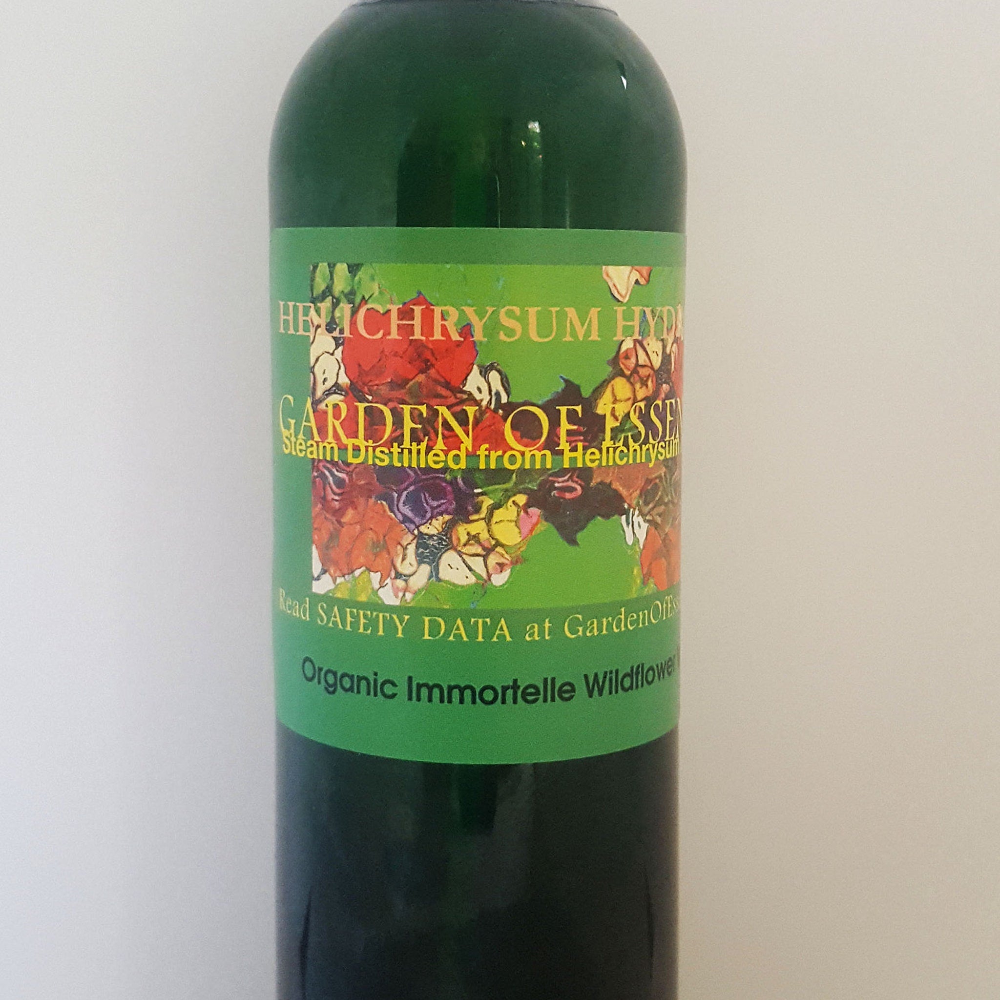 Green glass bottle with floral label, Garden of Essences branding visible, containing liquid
