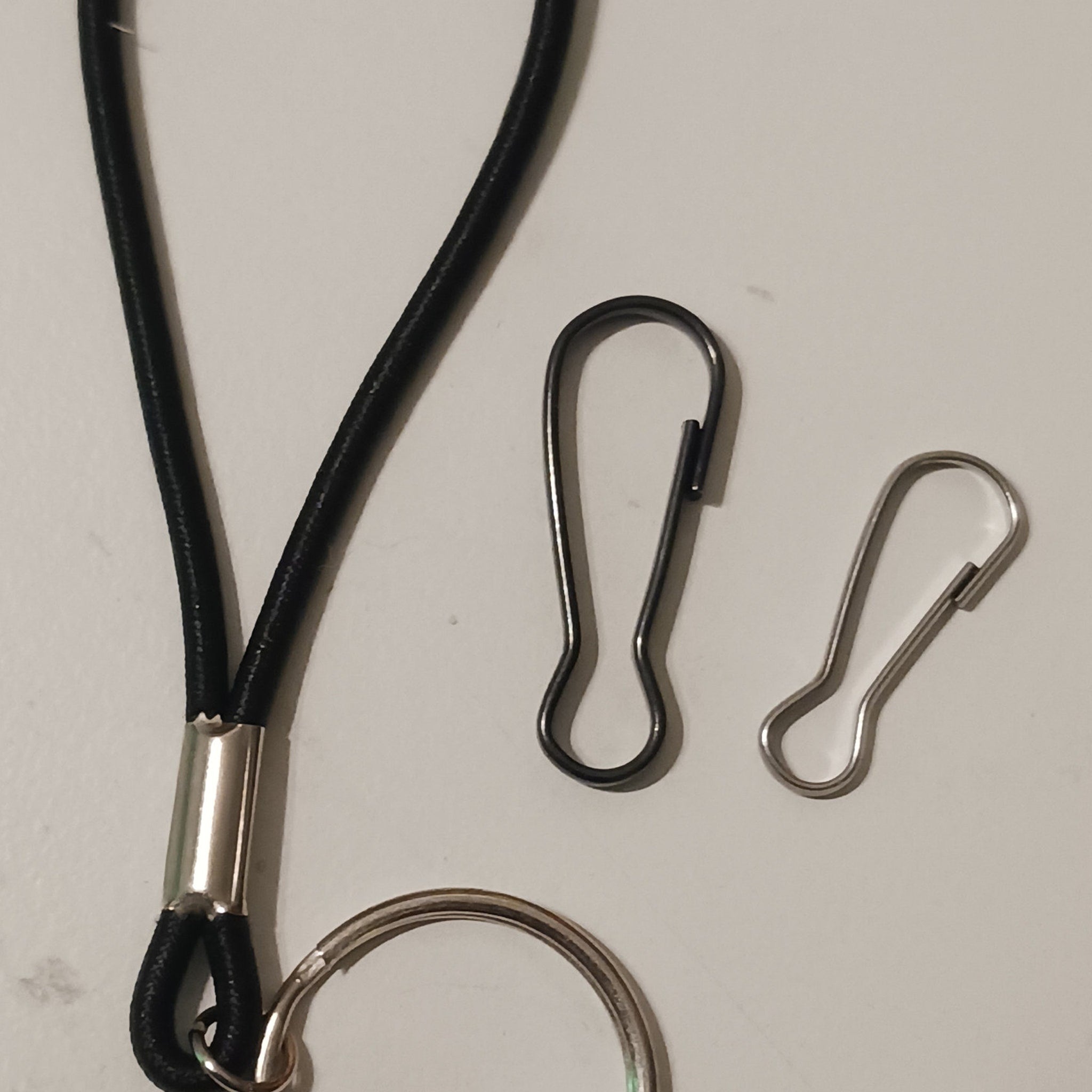 Lanyard with black cord and silver metal hardware, with two metal clips and a ring