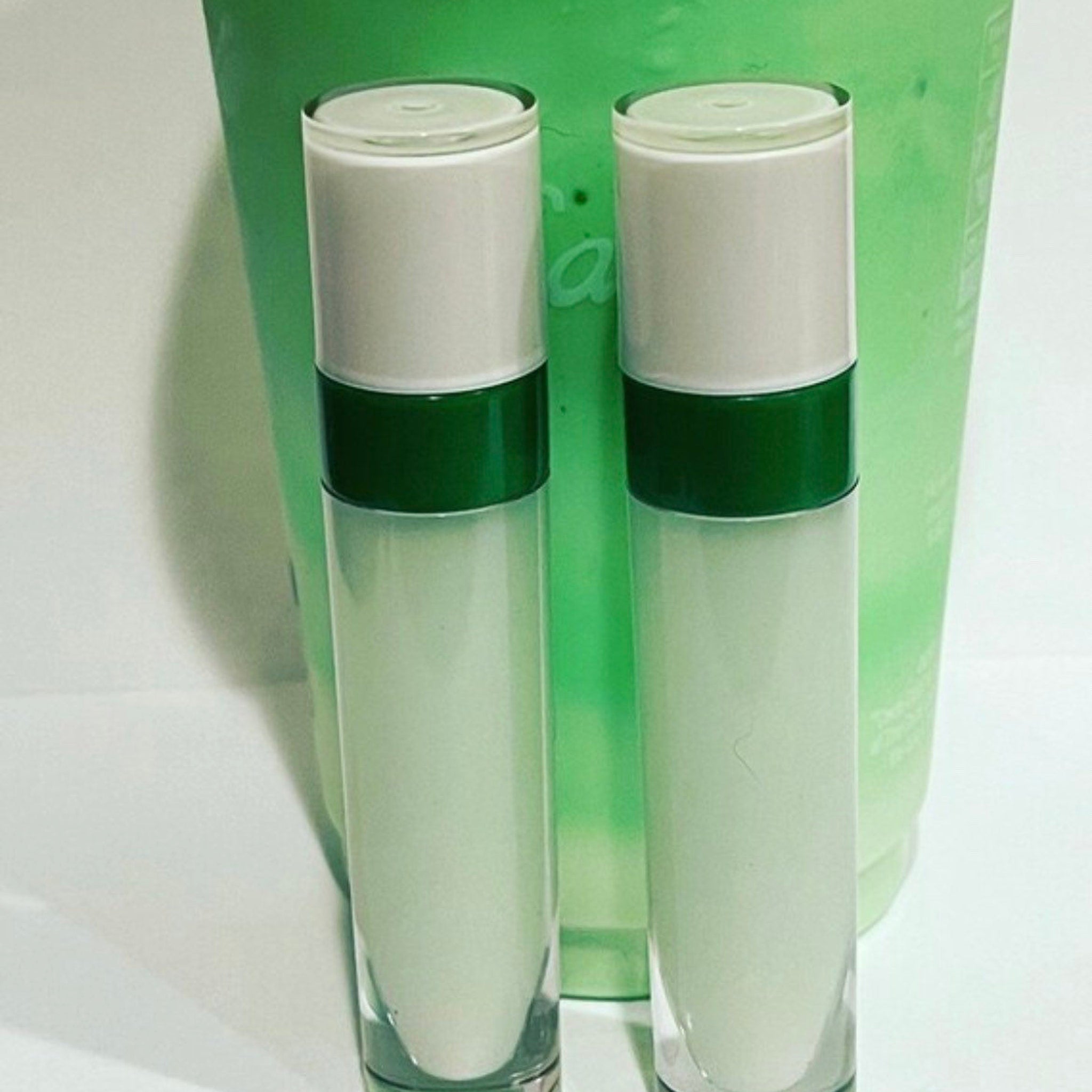 Lip gloss bottles with white, green and clear glass elements, product display