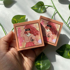 Eyeshadow palette with Niko Niko text, peach-colored compacts, anime illustration design held in hand