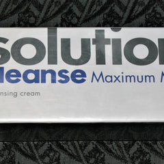 Solution Cleanse cream box with white and blue text on white background and black patterned surface