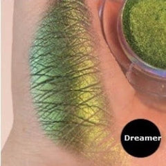Eyeshadow swatch with green and yellow shimmer, Dreamer brand label visible, applied on skin